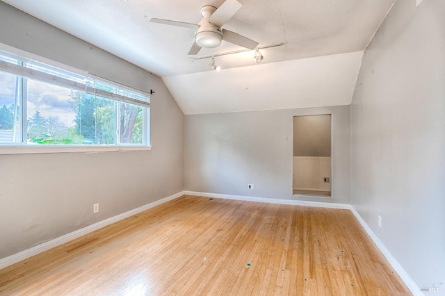 additional living space featuring wood-type flooring, baseboards, ceiling fan, and vaulted ceiling