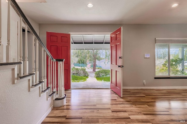 foyer entrance featuring recessed lighting, stairs, light wood-type flooring, and baseboards