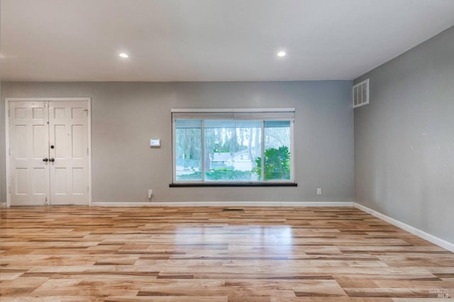 unfurnished room featuring recessed lighting, light wood finished floors, visible vents, and baseboards