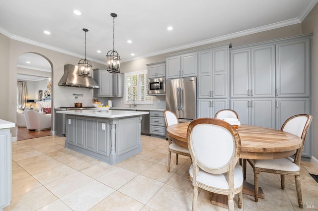 kitchen featuring gray cabinetry, wall chimney exhaust hood, light countertops, and appliances with stainless steel finishes