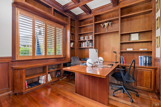 office featuring built in features, wooden walls, beam ceiling, and wood finished floors