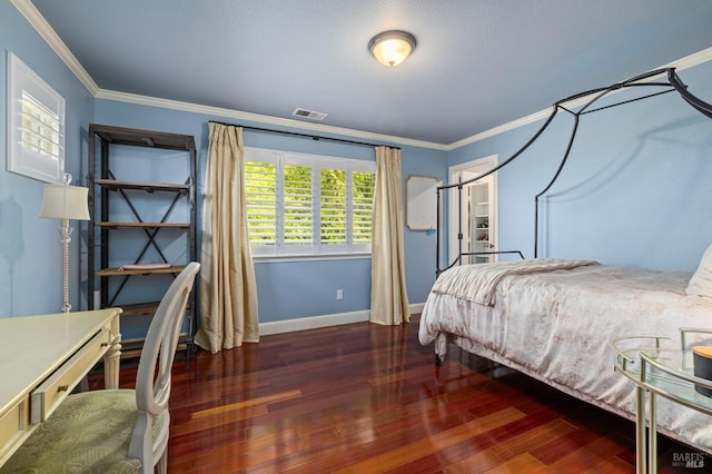 bedroom with hardwood / wood-style floors, crown molding, baseboards, and visible vents