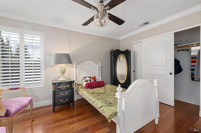 bedroom with visible vents, baseboards, a closet, hardwood / wood-style flooring, and crown molding