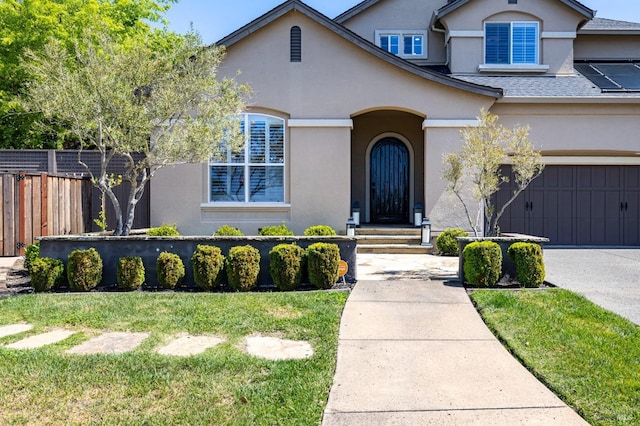 view of front of house featuring concrete driveway, fence, and stucco siding