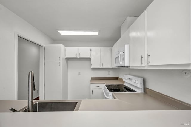 kitchen featuring light countertops, white cabinetry, and white appliances