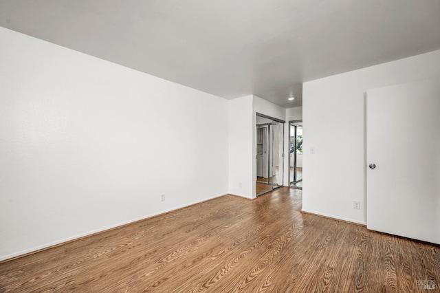 unfurnished room featuring wood finished floors and baseboards
