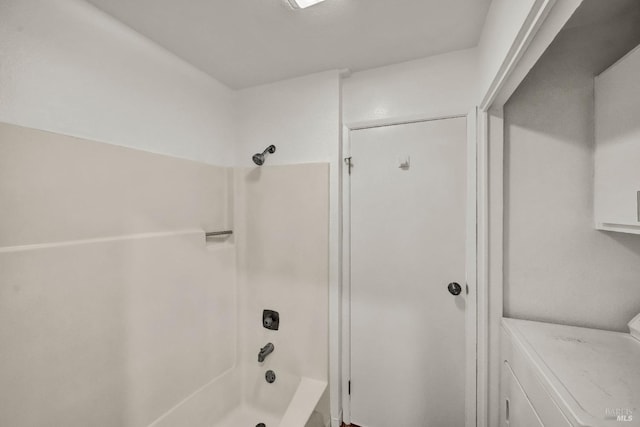 bathroom with washer / clothes dryer and washtub / shower combination