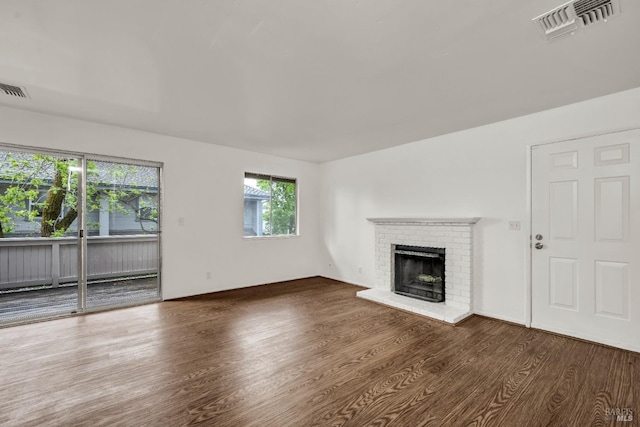 unfurnished living room featuring wood finished floors, a fireplace, and visible vents