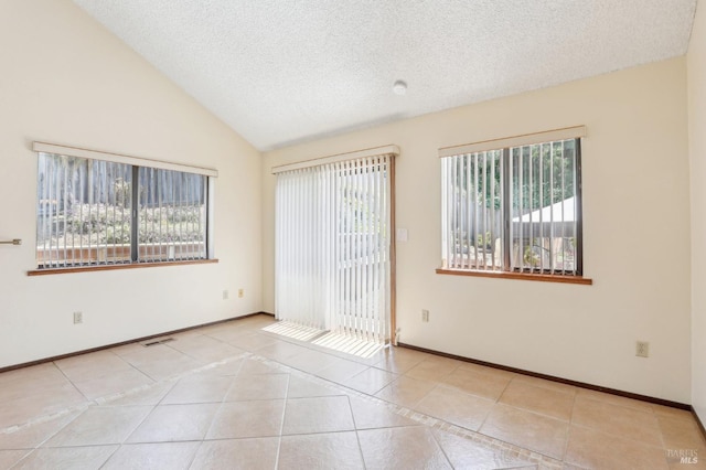 tiled spare room with plenty of natural light, vaulted ceiling, a textured ceiling, and visible vents