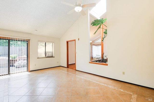 tiled spare room with high vaulted ceiling, ceiling fan, and baseboards