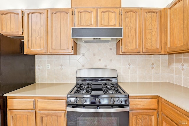 kitchen with light countertops, tasteful backsplash, black appliances, and under cabinet range hood