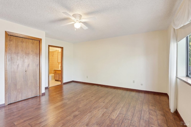 unfurnished bedroom featuring baseboards, a ceiling fan, a textured ceiling, and wood finished floors