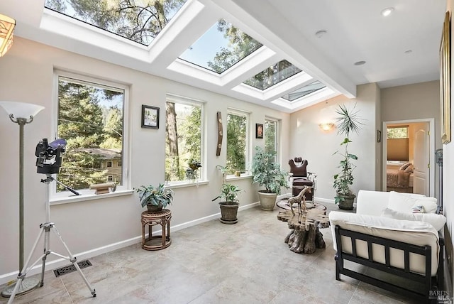 sunroom / solarium with a skylight, beam ceiling, and visible vents