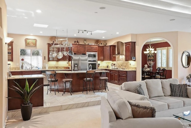 living room with recessed lighting, arched walkways, a notable chandelier, and light carpet