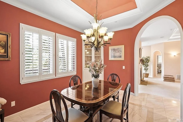 dining room with arched walkways, a notable chandelier, baseboards, and ornamental molding