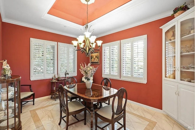 dining room featuring crown molding, a tray ceiling, baseboards, and an inviting chandelier