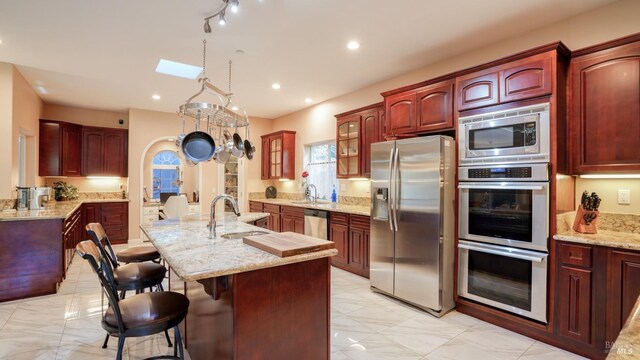 kitchen featuring a sink, reddish brown cabinets, and appliances with stainless steel finishes