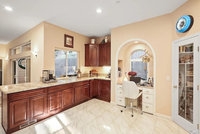 kitchen featuring a peninsula, light stone counters, visible vents, and recessed lighting