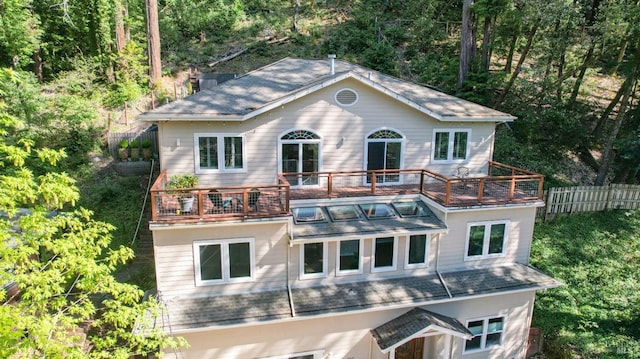 view of front of home with fence and a balcony