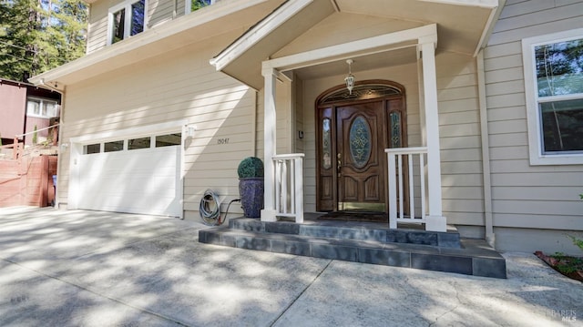 doorway to property featuring a garage and concrete driveway