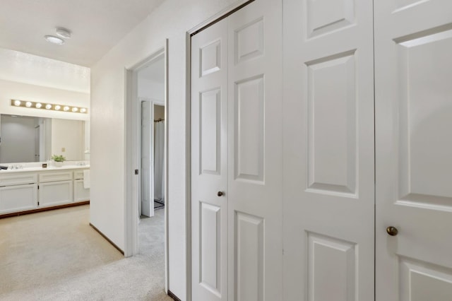 corridor featuring light colored carpet
