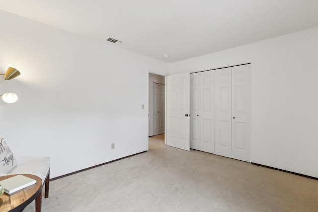 unfurnished room featuring visible vents, baseboards, and light carpet
