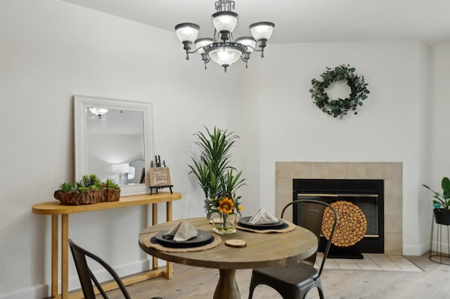 dining area featuring a notable chandelier and a fireplace