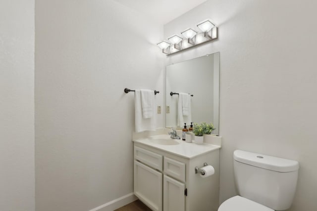 half bathroom with vanity and toilet