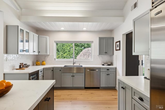 1423 Butterfield Rd, San Anselmo, CA 94960 - kitchen with stainless steel appliances, a sink, decorative backsplash, light wood-style floors, and gray cabinets