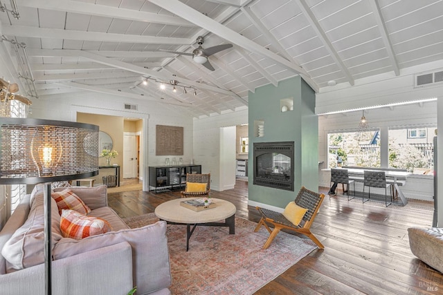 living room featuring a glass covered fireplace, wood finished floors, beamed ceiling, ceiling fan, and wood ceiling