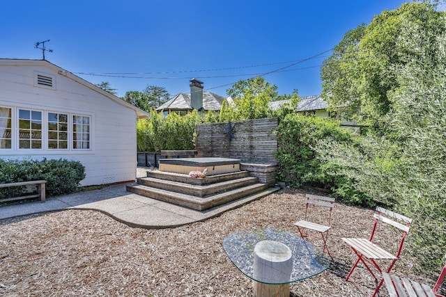 view of yard with fence, a patio area, and a hot tub