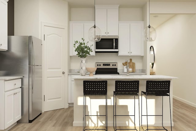 4507 Amble Ln, Riverbank, CA 95367 - kitchen with stainless steel appliances, light wood finished floors, a breakfast bar, and white cabinets