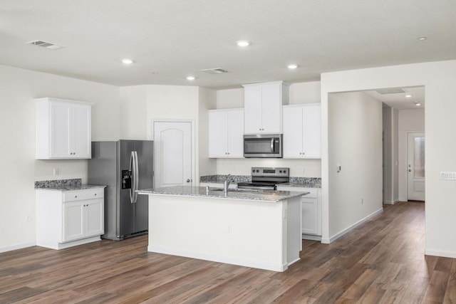 4507 Amble Ln, Riverbank, CA 95367 - kitchen featuring appliances with stainless steel finishes, dark wood-style floors, a center island with sink, white cabinetry, and recessed lighting