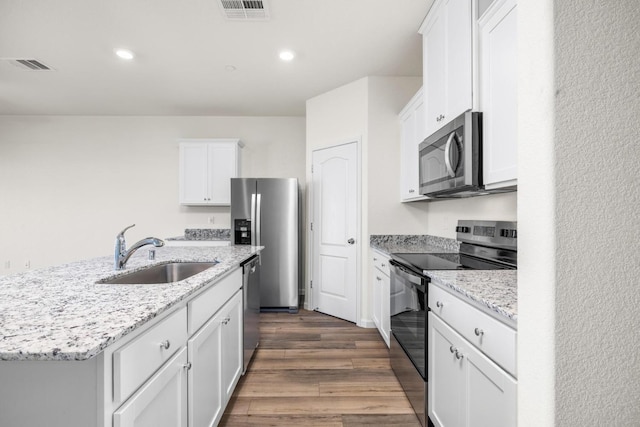 4507 Amble Ln, Riverbank, CA 95367 - kitchen featuring stainless steel appliances, a sink, white cabinetry, dark wood finished floors, and recessed lighting