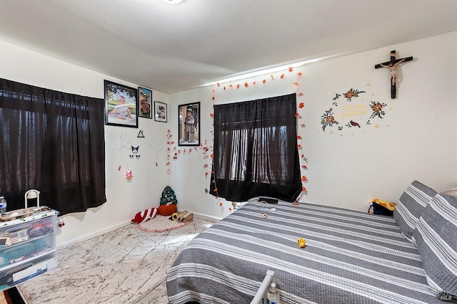bedroom featuring baseboards and a textured ceiling