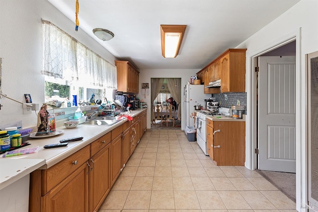 kitchen with tasteful backsplash, light tile patterned floors, a sink, light countertops, and white appliances