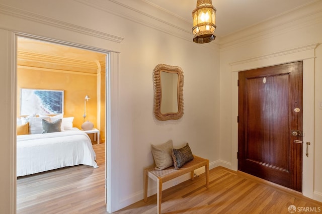 foyer entrance featuring baseboards, light wood-type flooring, and ornamental molding