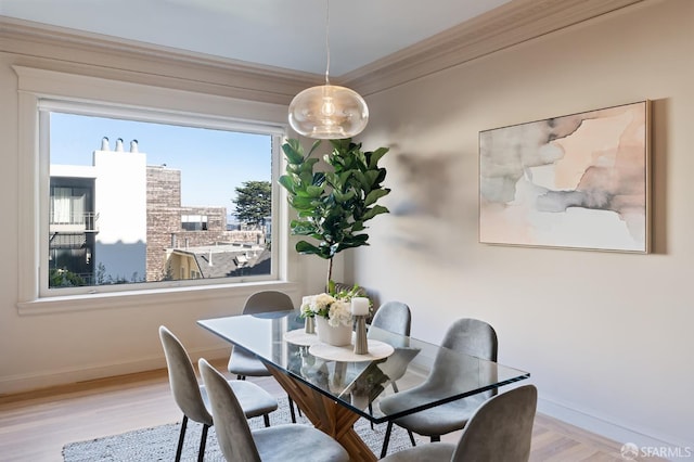 dining area with wood finished floors, baseboards, ornamental molding, and plenty of natural light