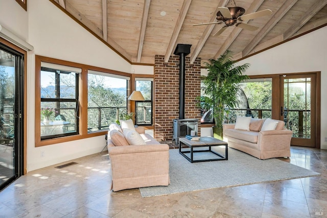 unfurnished living room with visible vents, a wood stove, high vaulted ceiling, and wood ceiling