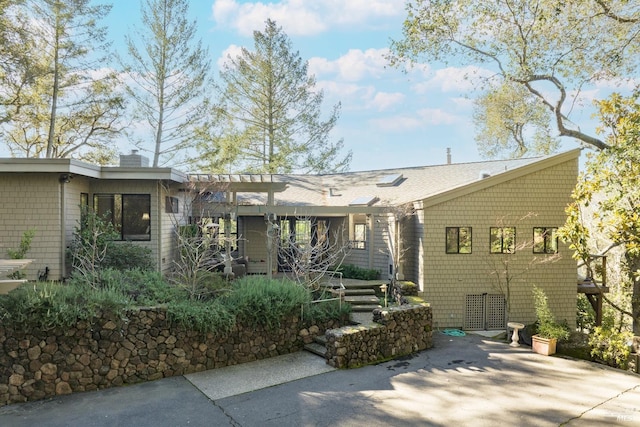 back of property featuring a chimney and a patio area