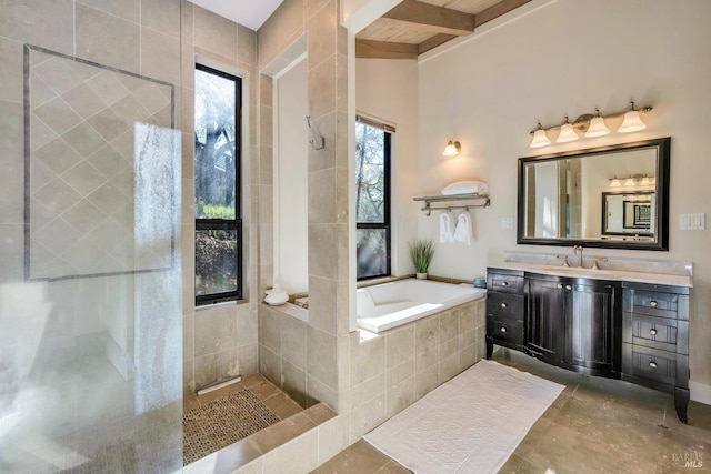 bathroom with vanity, a garden tub, and beam ceiling