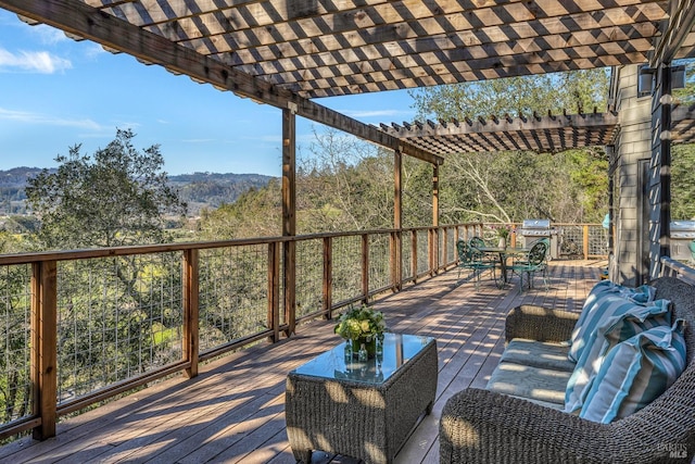wooden terrace featuring outdoor dining space, a pergola, a mountain view, and area for grilling