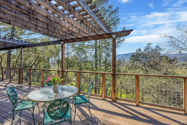 wooden deck with a pergola and outdoor dining space