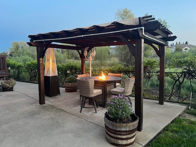 view of patio with fence, a fire pit, and a pergola