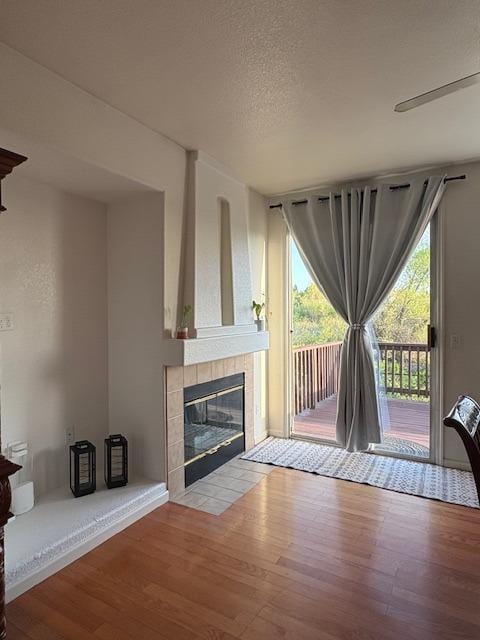 unfurnished living room featuring a textured ceiling, wood finished floors, and a fireplace