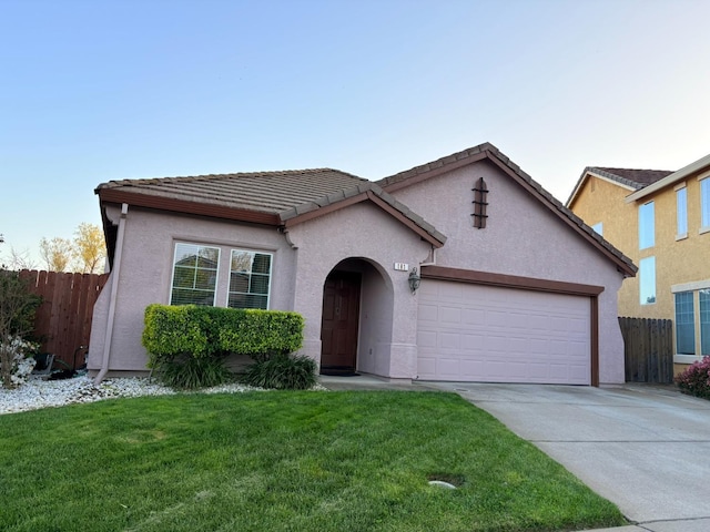 ranch-style home with driveway, a tiled roof, fence, and an attached garage
