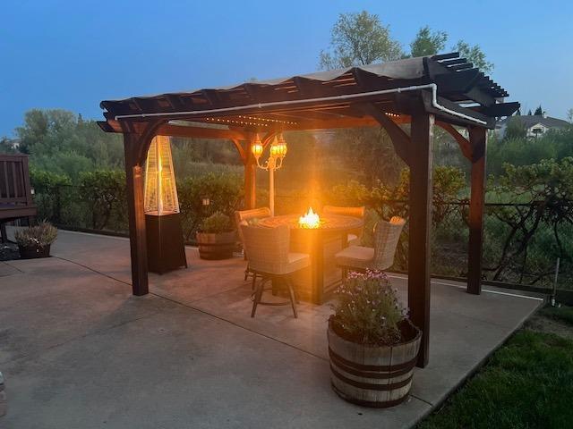 view of patio / terrace with a pergola, fence, and a fire pit