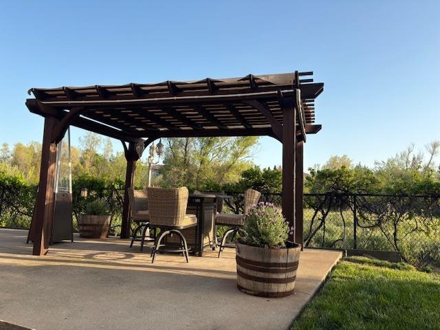 view of patio with outdoor dining area, a pergola, and fence