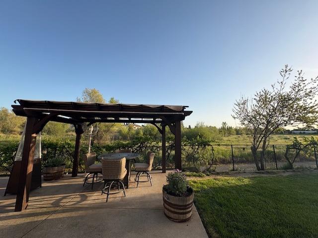 view of patio / terrace featuring outdoor dining area, a pergola, and fence