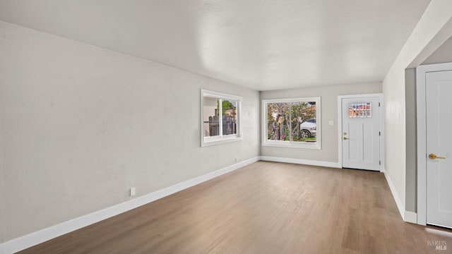 unfurnished room with wood finished floors and baseboards
